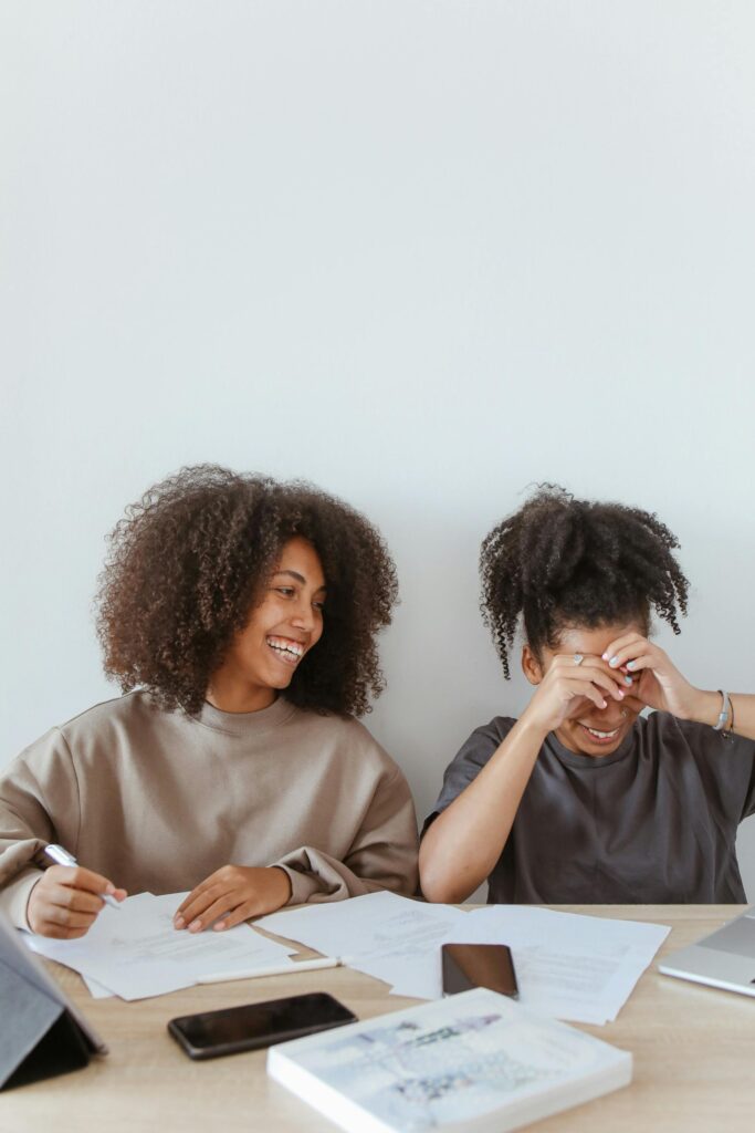 pexels-photo-5234743-5234743 Two teenage girls enjoying a study session at home, laughing and smiling.